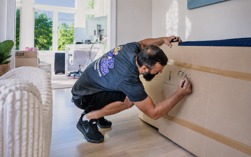 617 Boston Movers packing a fragile item.