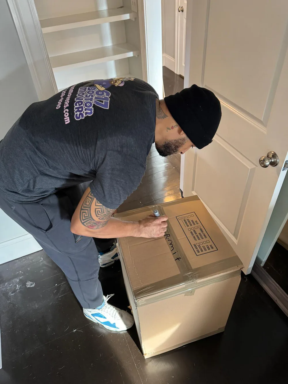 617 Boston Movers crew member packing boxes inside the Beverly home