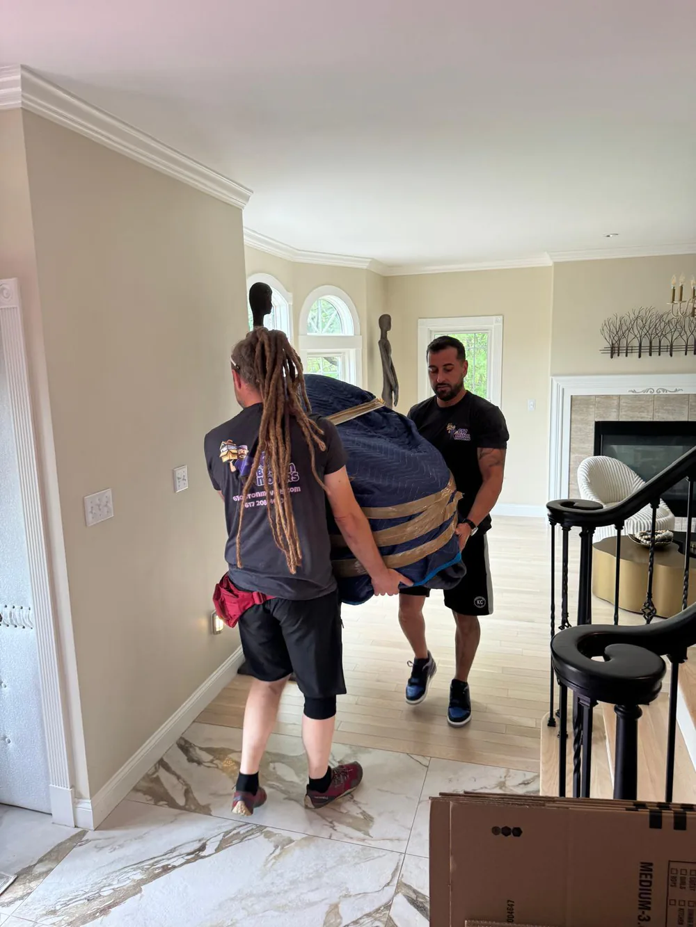617 Boston Movers crew carrying the wrapped grand piano during the Beverly-to-Duxbury move