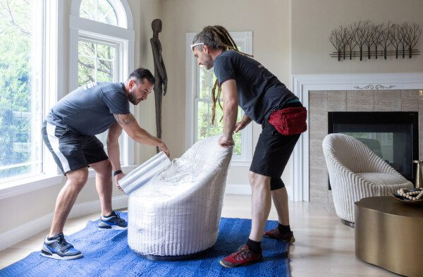 movers protective wrapping an expensive living room chair