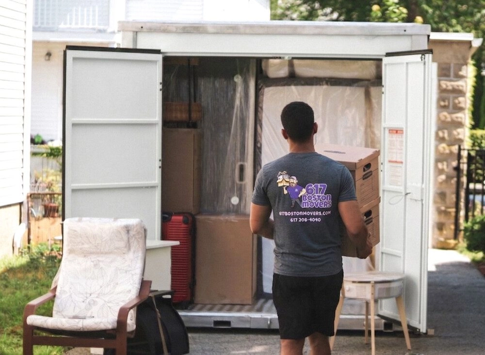 Mover carrying file boxes into a portable storage container