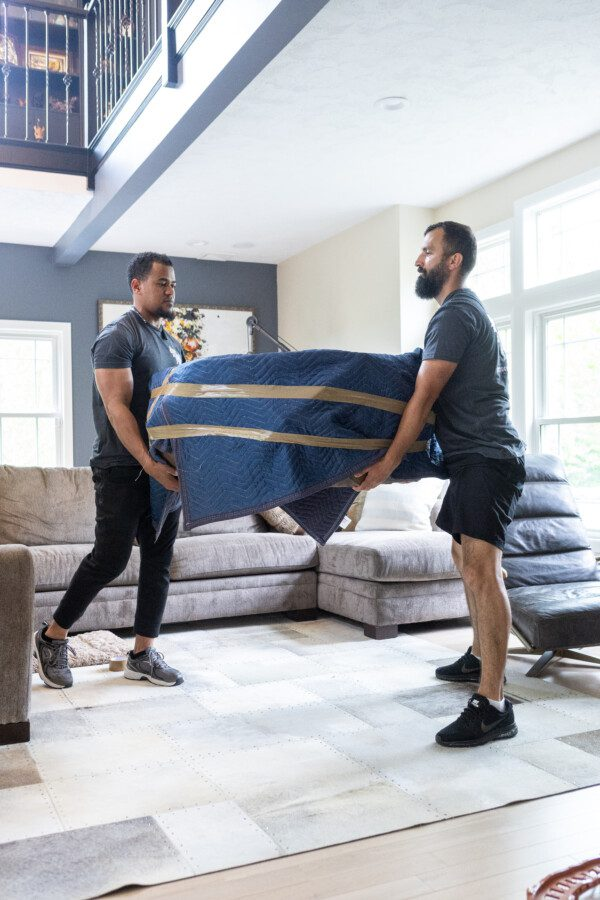 movers lifting heavy coffee table in a house
