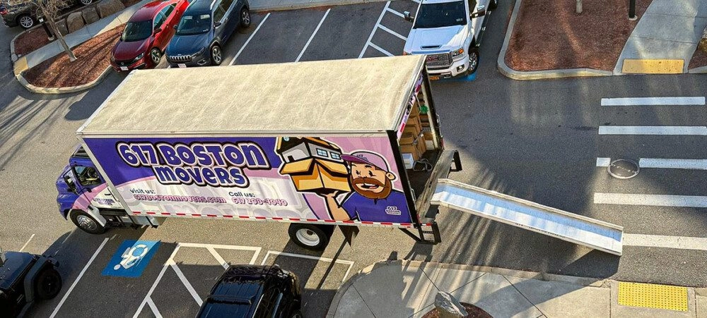 Aerial view of a 617 Boston Movers truck with a loading ramp in a parking lot